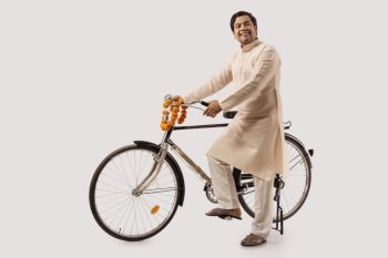 A HAPPY RURAL MAN POSING IN FRONT OF CAMERA WITH BICYCLE