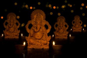 lord ganesha idols with diyas in front