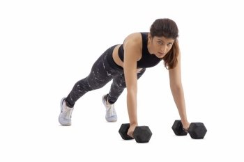 Woman doing pushups with dumbbells on a white background. 