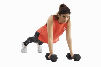Woman doing pushups with dumbbells on a white background. 