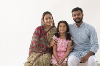 PORTRAIT OF A RURAL HUSBAND WIFE AND DAUGHTER SITTING AND POSING IN FRONT OF CAMERA