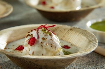 Dahi Vada or Dahi Bhalle a popular Indian snack is fried lentil dumplings, topped with curd, sweet and green chutney and spices