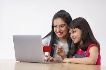 A HAPPY MOTHER AND DAUGHTER DOING ONLINE TRANSACTION