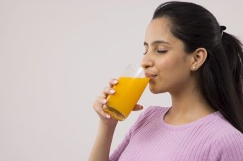 A TEENAGER DRINKING FRUIT JUICE