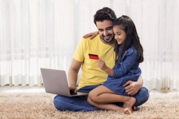 A DAUGHTER SITTING WITH FATHER WHILE HOLDING DEBIT CARD