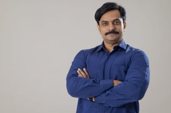 Man posing in front of camera with folding hands