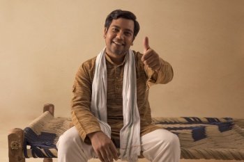 A RURAL MAN HAPPILY SHOWING THUMBS UP IN FRONT OF CAMERA