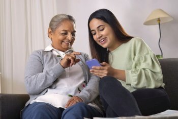 Grandmother and granddaughter using smartphone together at home