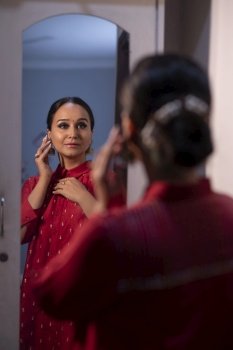 Sikh woman getting dressed in front of mirror