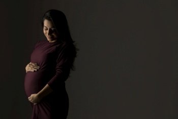 Pregnant woman holding her baby bump in anticipation. 