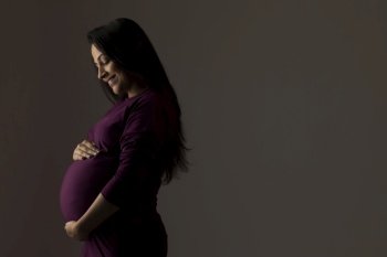 Pregnant woman thinking about her baby and smiling.