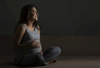 Pregnant woman thinking about her baby and smiling. 