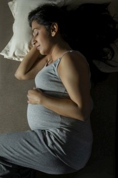 Pregnant woman sleeping comfortably on the bed. 