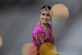 Portrait of a lady in a beautiful pink saree smiling 