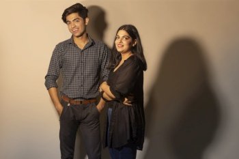 A STYLISH BROTHER AND SISTER POSING TOGETHER IN FRONT OF CAMERA