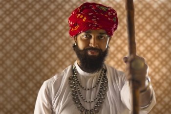 Close-up portrait of Rajasthani young man standing with a stick