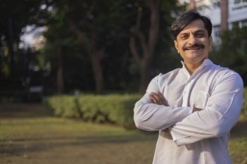 Middle age man in white kurta standing at park in the morning