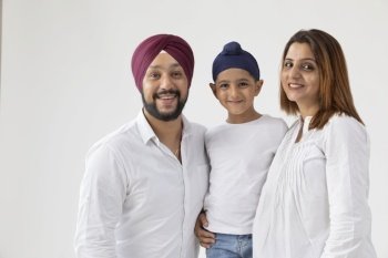 A SIKH FAMILY SMILING AND POSING