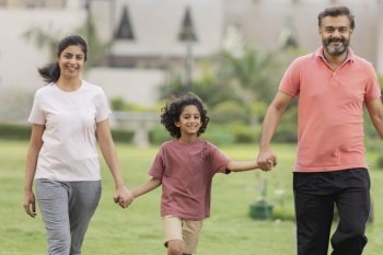 Portrait of happy family walking together in the park