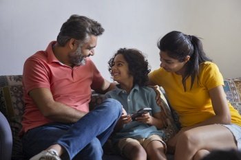 Family watching smartphone and having fun together in living room