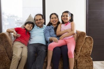 Indian family members sitting in sofa together with smile