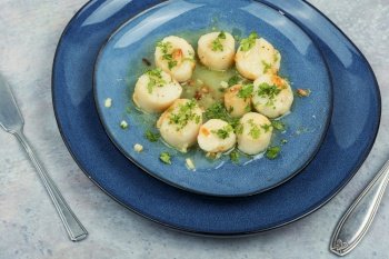 Roasted or seared scallops with green on a plate. Roasted scallops on a plate
