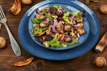 Salad with grilled forest mushrooms, onions, herbs and walnuts. Concept healthy food, rustic style.. Spicy mushroom salad with onions and walnuts.