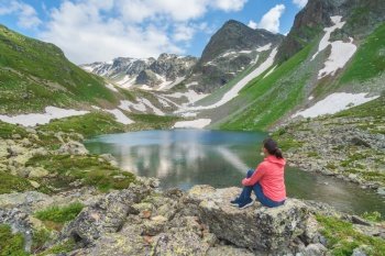 Landscape of Caucasus Dukka lake in mountain. Woman enjoy mountian nature. Emotional and travel relax scene.