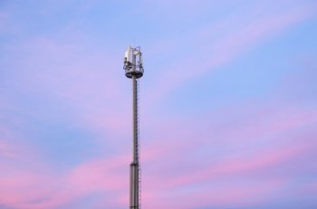 Cell phone tower during the sunset. Telecomunication scene.