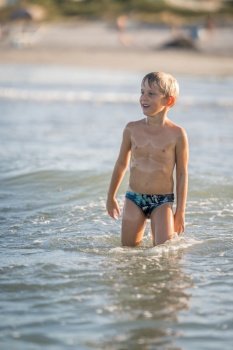 Wet child thinking on the sea, happy kid enjoying on the beach resort, summer concept holiday, Emilia Romagna, Italy.