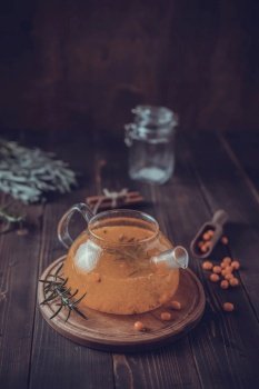 Teapot of sea ????buckthorn tea on wooden table