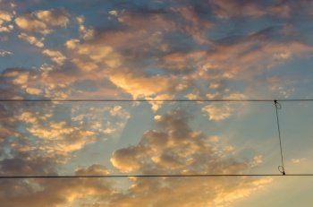 Electrical wires on cloudy sky at sunset background