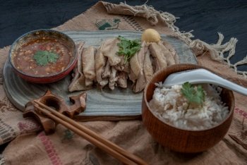 Asian food style marinated steamed chicken (Betong Chickken) with Rice and sauce on ceramic plate. Oblique view from the top.