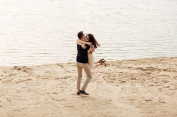 Romantic couple is hugging and having fun outdoors. elegant and stylish woman and man in love are walking along the lake. Happy moments together. love story.. Romantic couple is hugging and having fun outdoors. elegant and stylish woman and man in love are walking along the lake. Happy moments together. love story