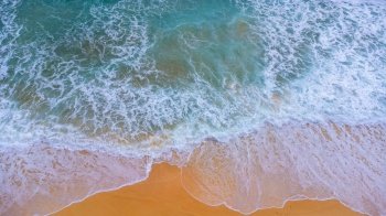 Beautiful sea waves and white sand beach in the tropical island. Soft waves of blue ocean on sandy beach background from top view from drones. Concept of relaxation and travel on vacation.