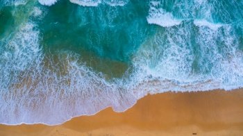 Beautiful sea waves and white sand beach in the tropical island. Soft waves of blue ocean on sandy beach background from top view from drones. Concept of relaxation and travel on vacation.