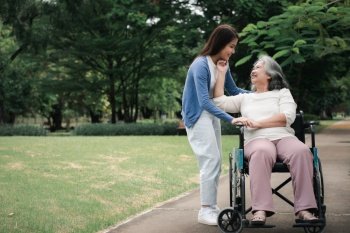 Asian careful caregiver or nurse taking care of the patient in a wheelchair.  Concept of happy retirement with care from a caregiver and Savings and senior health insurance, a Happy family