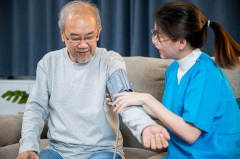 Asian nurse visit patient senior man at home she measuring arterial blood pressure on arm in living room, Doctor woman examine do checking old man client heart rate with pulsimeter monitor, Healthcare