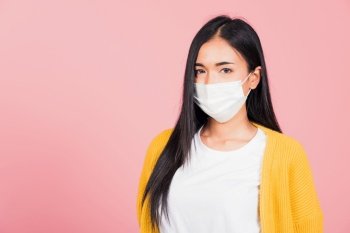 Closeup face Asian beautiful young woman wearing medical mask protection against germs for prevent infection coronavirus, COVID-19, studio shot isolated on pink background, medical health care concept