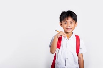Asian toddler smiling happy wear student thai uniform red pants holding pencil for writers notebook in studio shot isolated on white background, Portrait little children boy preschool, Back to school