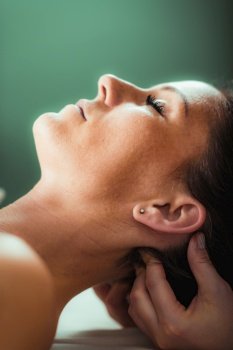 Neck massage in a massage salon, woman having a relaxing neck massage.