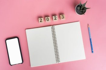 Notebooks with empty goals for 2023 year and phone on color background