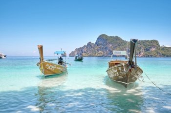 The Landscape of beach and ocean on a sunny day at Phi Phi Islands with a tourist boat, Thailand