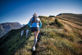 Woman sporty mountain running athlete du crest of meadow