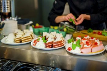Buffet with slides of pies and cakes prepared by the cook for a party or party in a catering facility. Delicious sweet buffet with  wedding cake and other desserts.