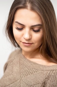 Portrait of beautiful young caucasian woman with closed eyes after eyelash extension procedure and permanent makeup. Woman with closed eyes after cosmetic procedure