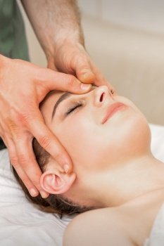 Pretty young caucasian woman receiving a head massage by a male massage therapist in a beauty salon. Pretty young caucasian woman receiving a head massage by a male massage therapist in a beauty salon.
