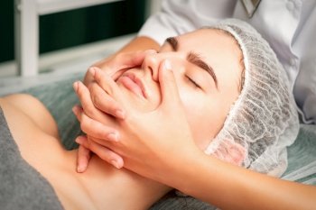 A young caucasian woman getting facial massage in a spa. A young caucasian woman getting facial massage in a spa.