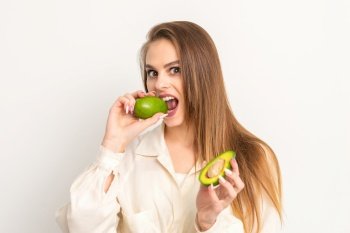 Diet nutrition. Beautiful young caucasian woman biting organic green avocado on white background. Healthy lifestyle, health concept. Diet nutrition. Beautiful young caucasian woman biting organic green avocado on white background. Healthy lifestyle, health concept.