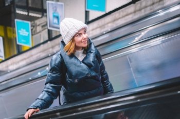 Portrait of woman in winter clothing at subway station, girl rises on an escalator. Underground in Stockholm.